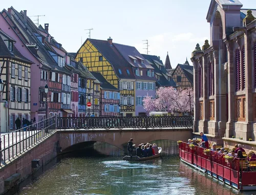 Colmar depuis un pont sur le canal Vue depuis un pont à Colmar, montrant les maisons à colombages colorées bordant le canal.