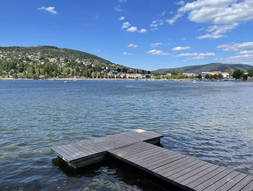 Vue panoramique sur le lac de Gérardmer, entouré de forêts et de collines vosgiennes.