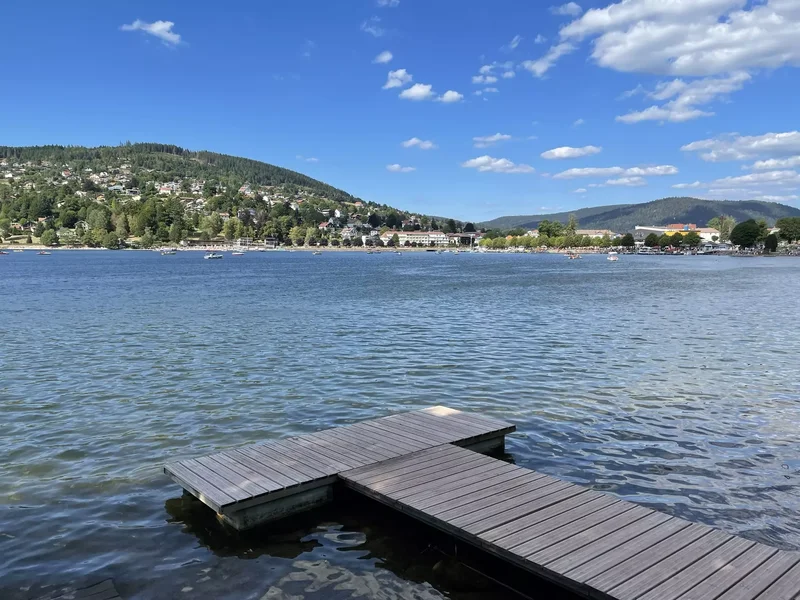 Vue panoramique sur le lac de Gérardmer, entouré de forêts et de collines vosgiennes.