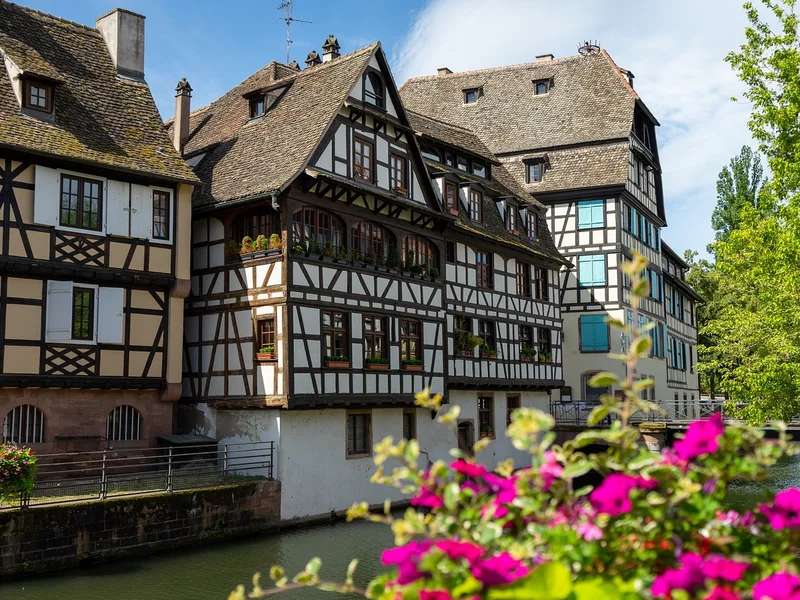 Maison traditionnelle à Strasbourg Maison traditionnelle à colombages dans le centre historique de Strasbourg, entourée de rues pavées.