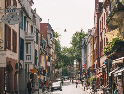 Centre-ville de Freiburg im Breisgau avec rues pavées, bâtiments historiques et vie urbaine.