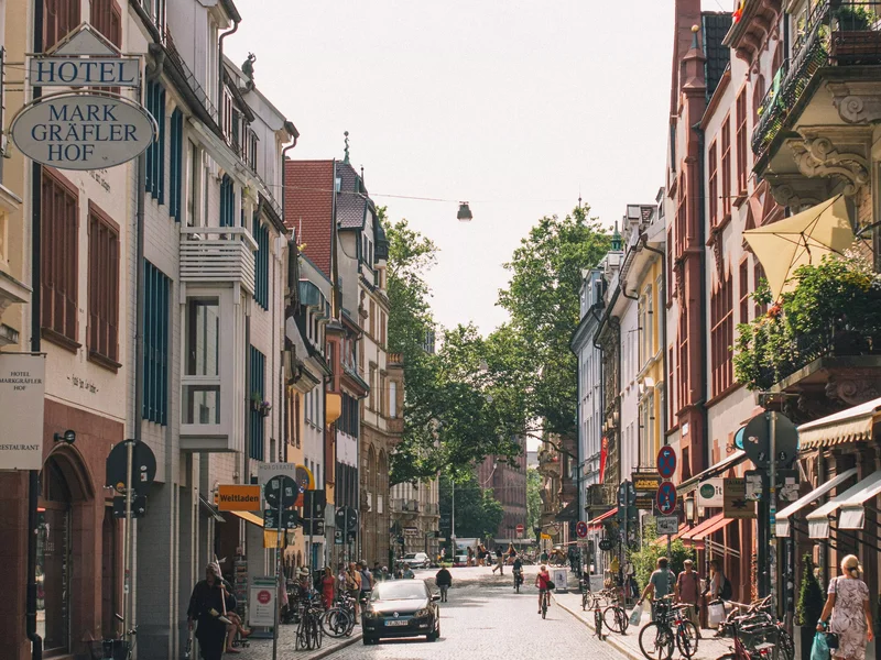 Centre-ville de Freiburg im Breisgau avec rues pavées, bâtiments historiques et vie urbaine.