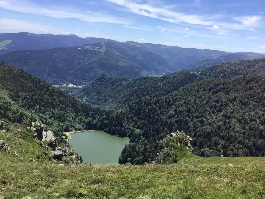 Vue sur le barrage de Schiessrothried entouré de forêt, observé depuis les hauteurs du Hohneck.