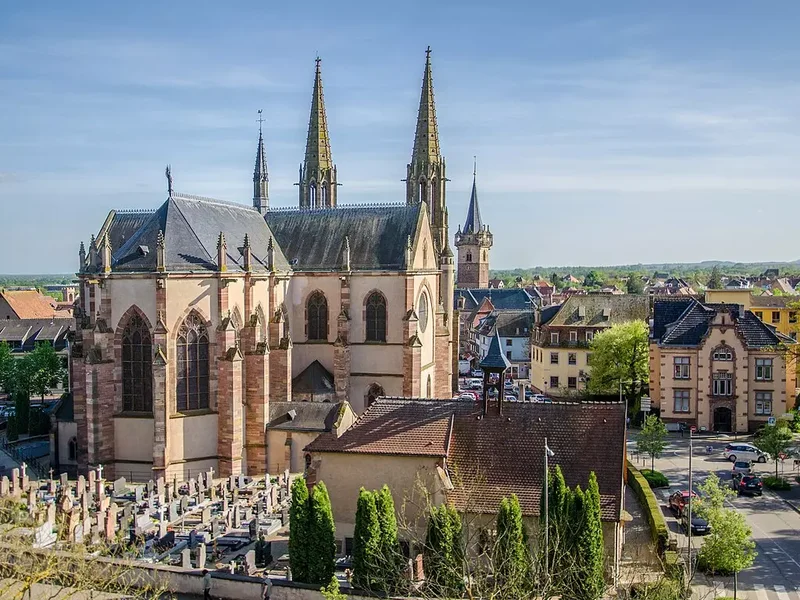 Vue de l’église Saints-Pierre-et-Paul avec son clocher et la place environnante.