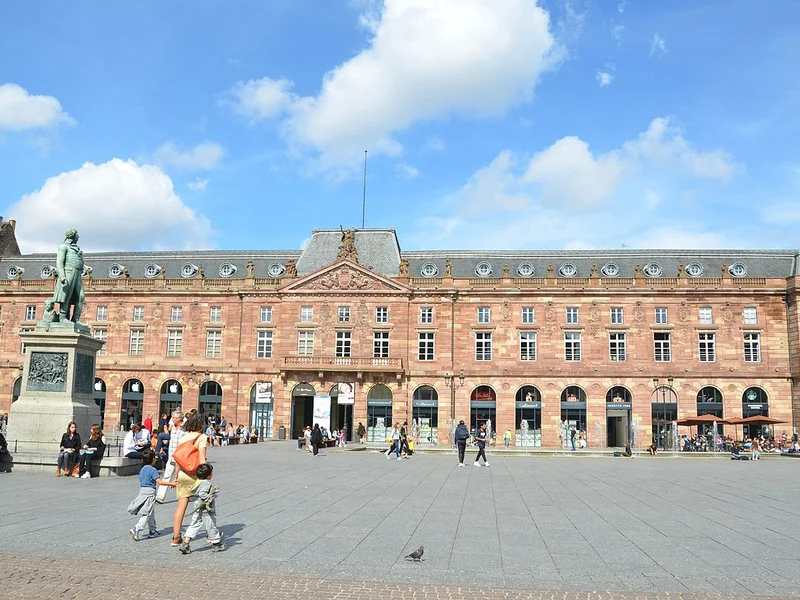 Vue de la Place Kléber, place centrale animée de Strasbourg, entourée de bâtiments historiques.
