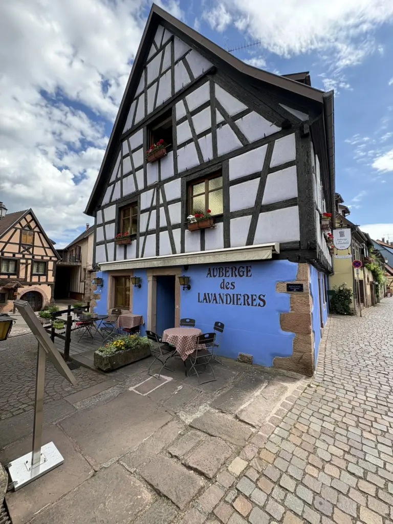 Auberge traditionnelle à colombages colorés bordant une rue du centre historique de Bergheim