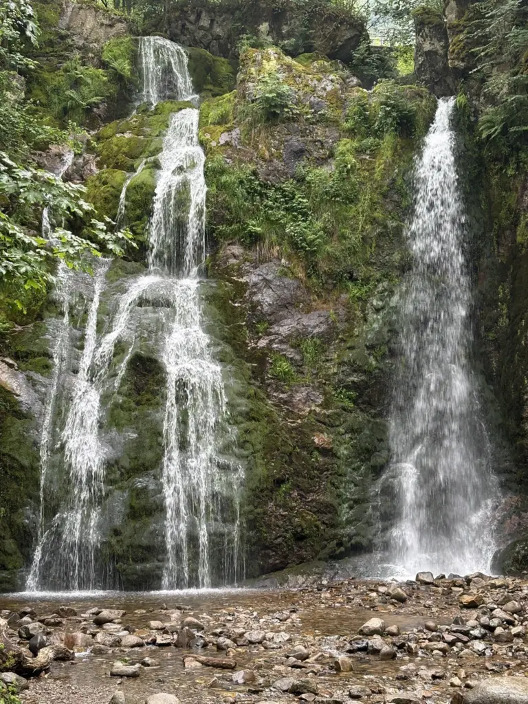 Cascade du Heidenbad entourée de forêt, avec l'eau s'écoulant sur des rochers moussus en Alsace.
