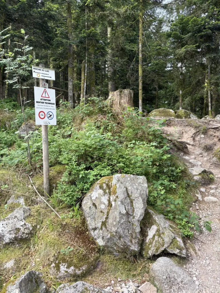 Panneau indiquant le départ du sentier en forêt vers le Rocher du Lac.