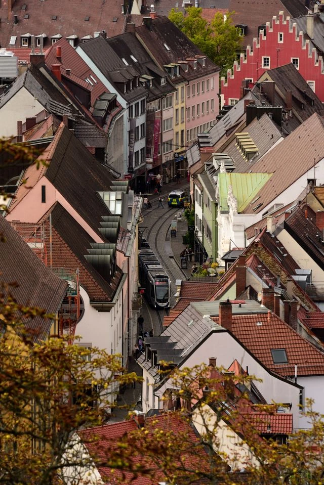 Rue du centre-ville de Freiburg im Breisgau avec un tramway et les façades historiques.