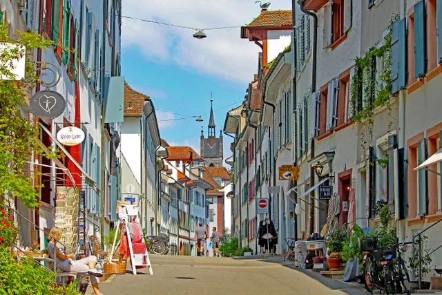 Rue animée de Bâle et son architecture colorée.