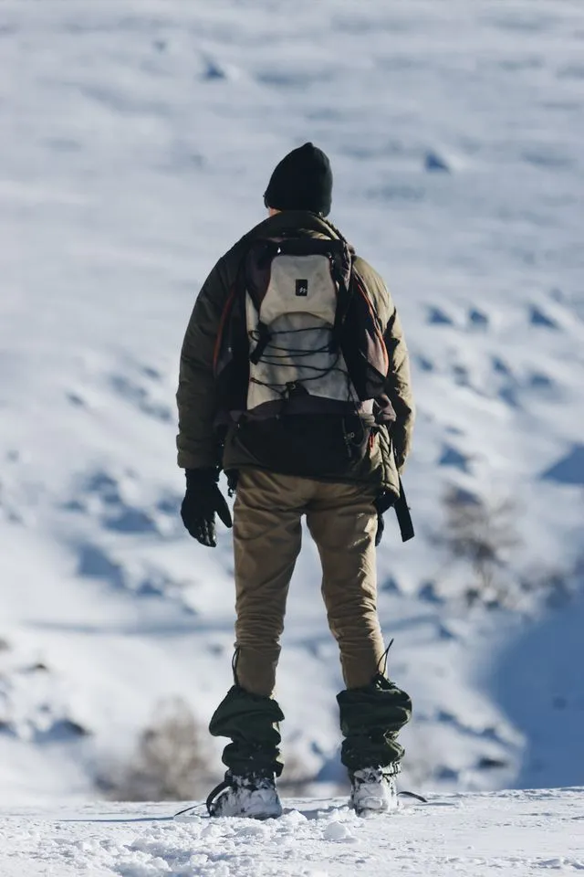 Randonneur marchant dans les Vosges enneigées avec des vêtements adaptés aux conditions hivernales
