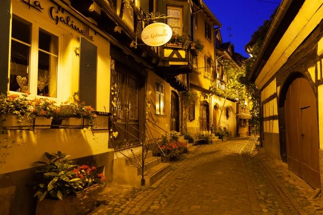 Ruelle du centre historique d’Eguisheim à la tombée de la nuit.